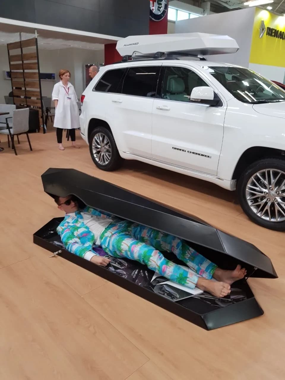 Človek v Alumined boxe na autosalóne
